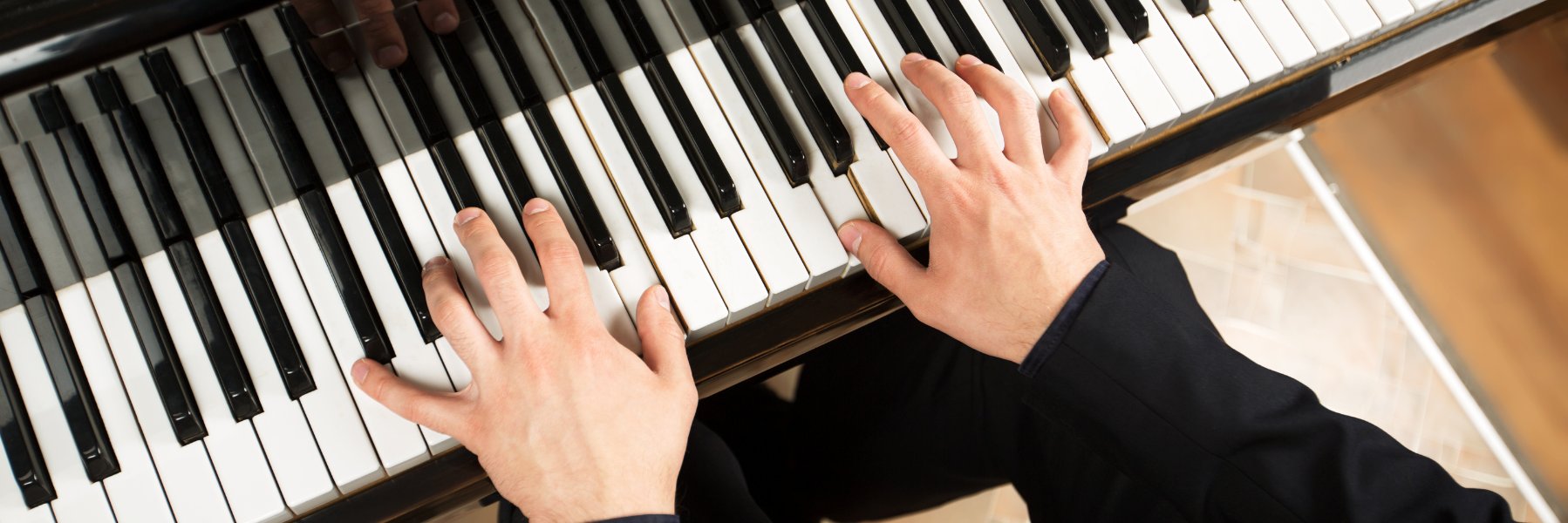 Deux mains jouant sur un piano à queue
